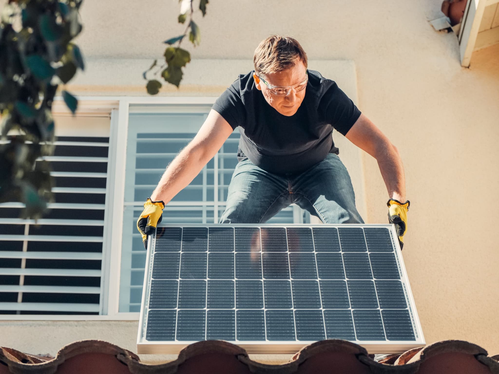 Technicien PSUN+ installant des panneaux photovoltaïques sur un toit